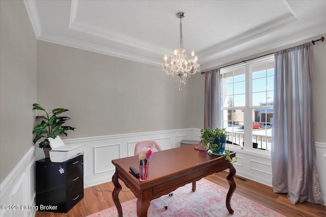 home office featuring a raised ceiling, an inviting chandelier, hardwood / wood-style floors, and crown molding