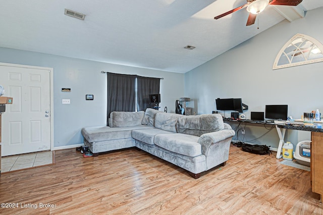 living room with ceiling fan, hardwood / wood-style floors, and vaulted ceiling with beams