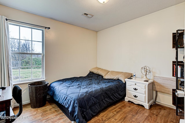 bedroom featuring multiple windows and light hardwood / wood-style floors