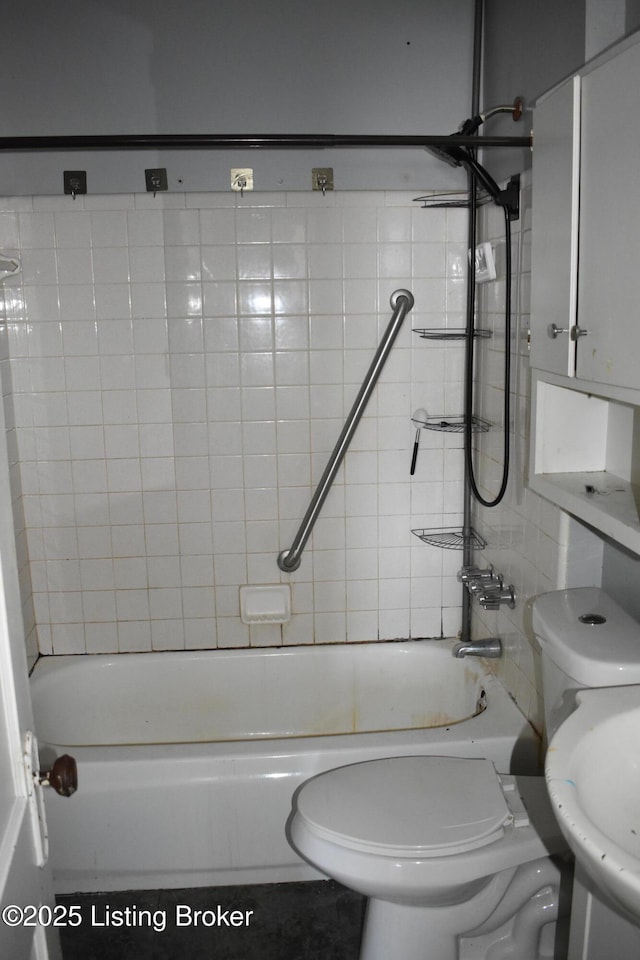 bathroom with toilet and tiled shower / bath