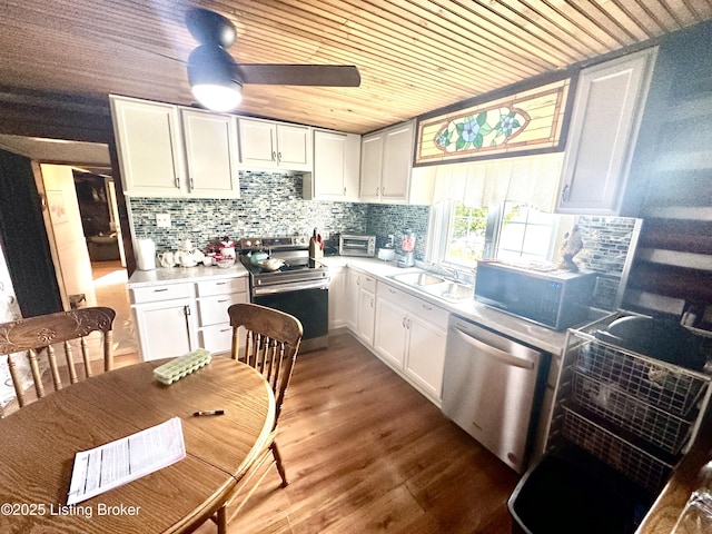 kitchen with stainless steel appliances, sink, white cabinetry, hardwood / wood-style flooring, and wood ceiling