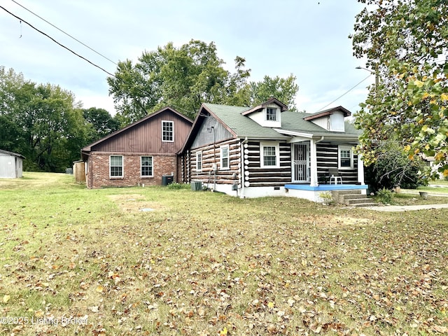 rear view of property featuring a lawn and a porch