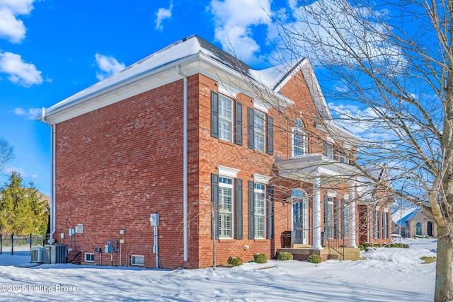 view of snowy exterior with cooling unit