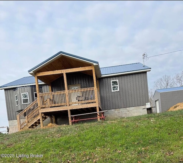 rear view of house with a yard and a deck