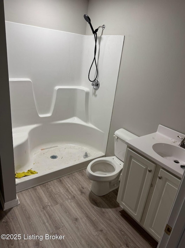 bathroom featuring vanity, hardwood / wood-style flooring, toilet, and walk in shower