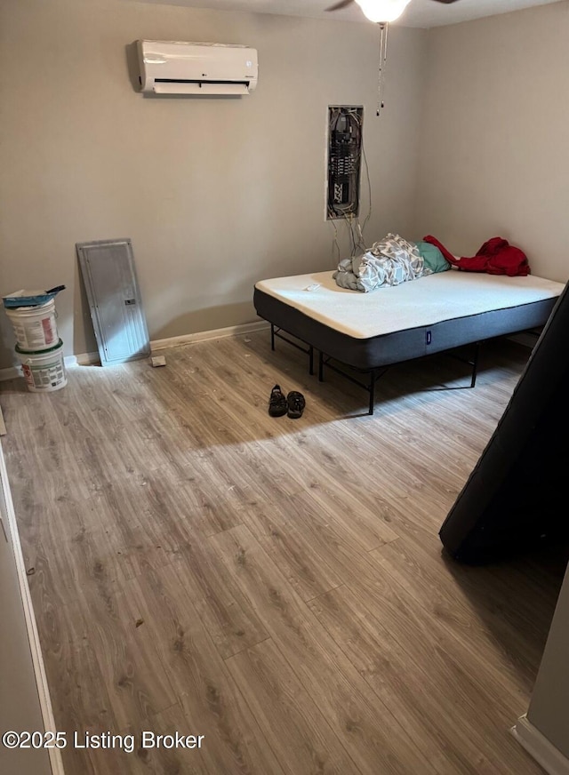 bedroom featuring hardwood / wood-style floors and an AC wall unit