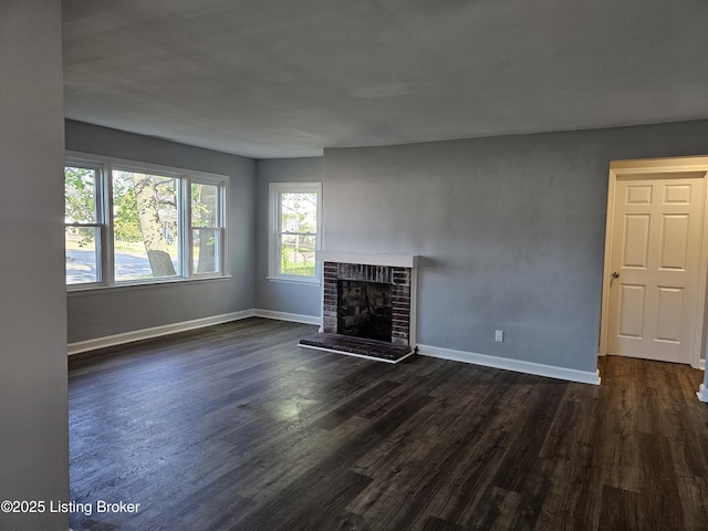 unfurnished living room with dark hardwood / wood-style floors and a brick fireplace