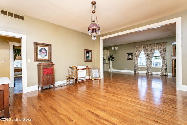 interior space featuring wood-type flooring and a chandelier