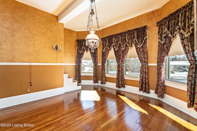 exercise room with hardwood / wood-style flooring, a chandelier, and a healthy amount of sunlight