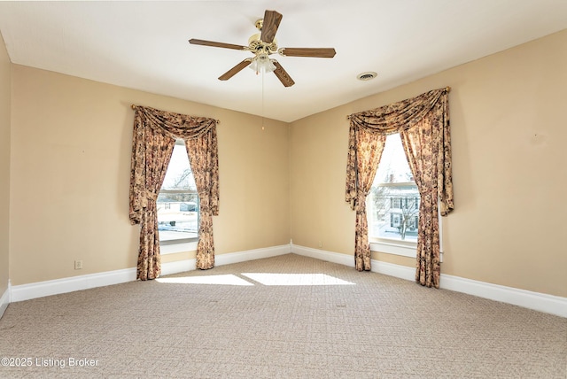 empty room with ceiling fan, plenty of natural light, and light colored carpet