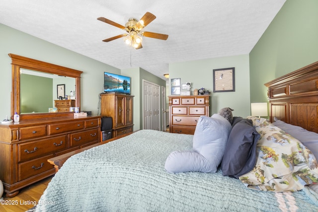 bedroom with a closet, ceiling fan, a textured ceiling, and light hardwood / wood-style flooring