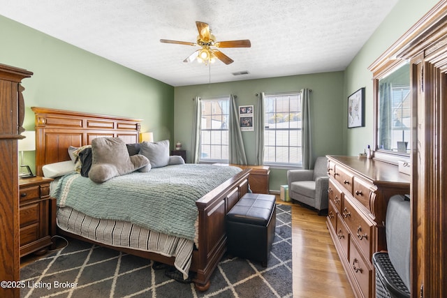 bedroom featuring a textured ceiling, ceiling fan, and hardwood / wood-style floors