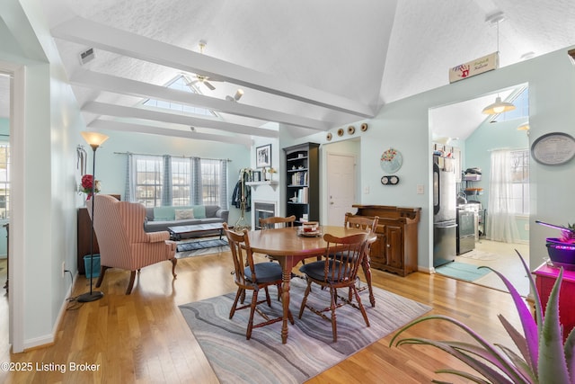 dining space featuring ceiling fan, vaulted ceiling, and light hardwood / wood-style flooring