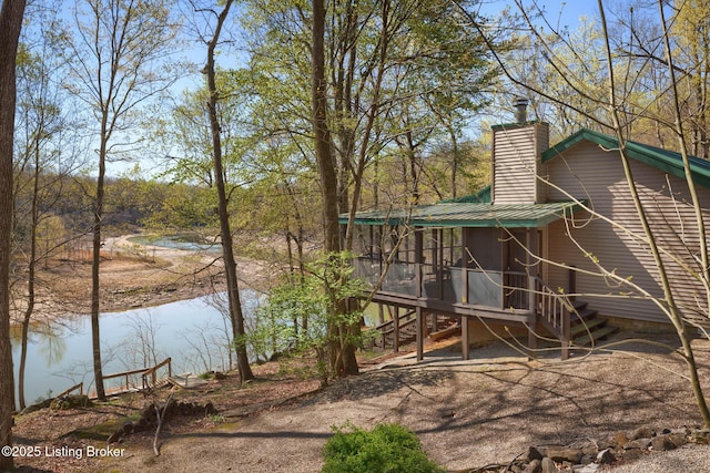 exterior space with a sunroom and a water view