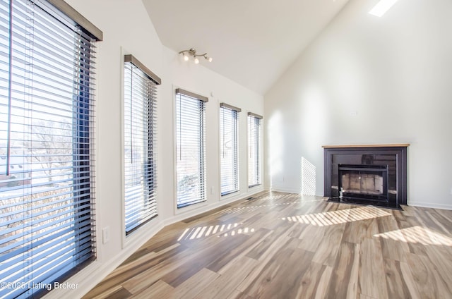 unfurnished living room with light wood-type flooring and vaulted ceiling