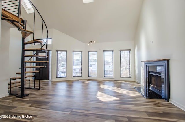 unfurnished living room featuring a high ceiling and dark wood-type flooring