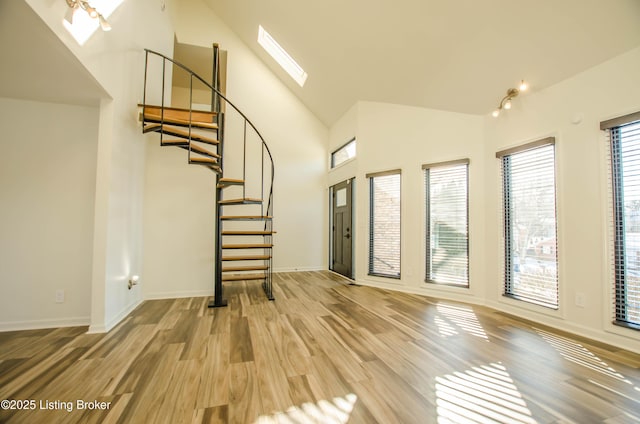 interior space featuring hardwood / wood-style flooring and vaulted ceiling with skylight