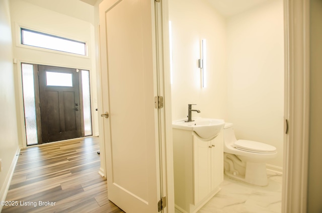 bathroom featuring toilet, hardwood / wood-style floors, and vanity