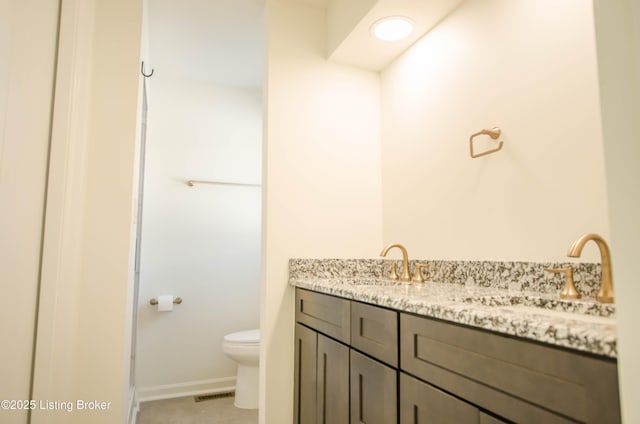 bathroom featuring tile patterned floors, vanity, and toilet