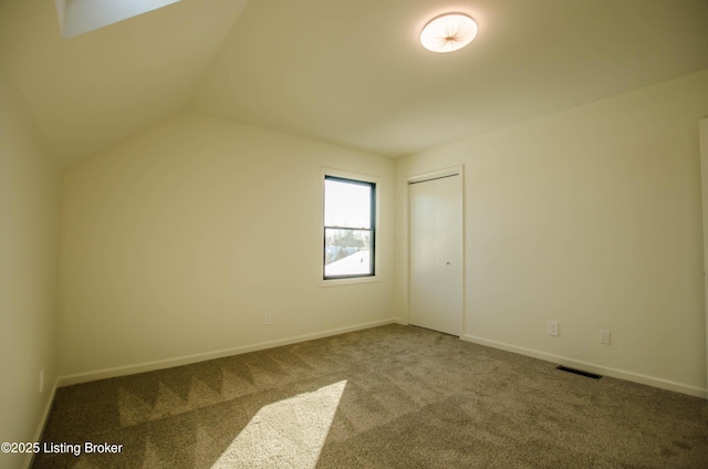 spare room with lofted ceiling and carpet floors