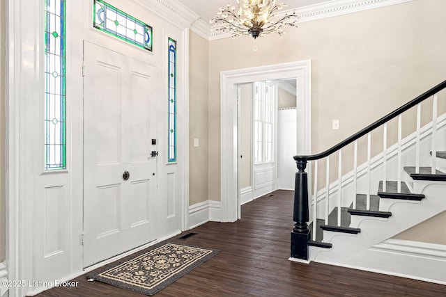 entryway featuring dark hardwood / wood-style flooring, crown molding, and a chandelier