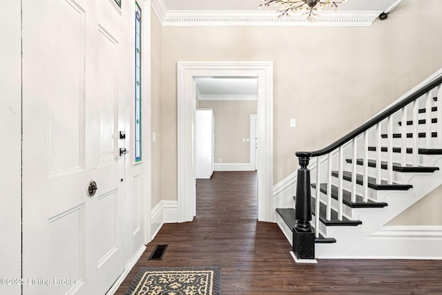 entrance foyer with ornamental molding, dark hardwood / wood-style floors, and a notable chandelier