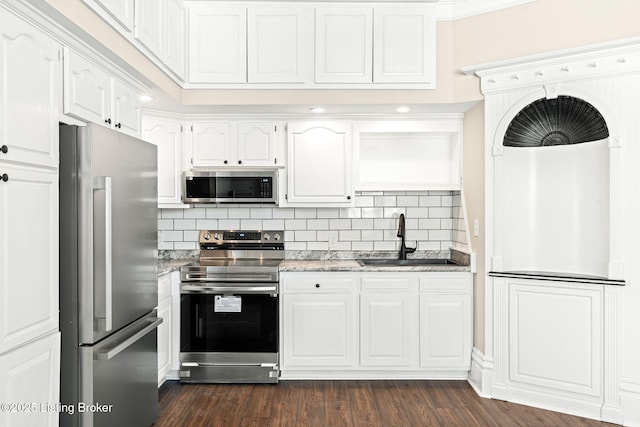 kitchen featuring appliances with stainless steel finishes, sink, light stone counters, and white cabinetry