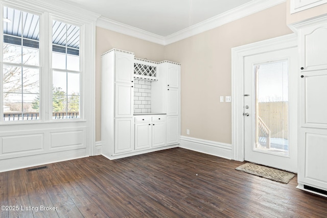 doorway with dark hardwood / wood-style flooring and crown molding