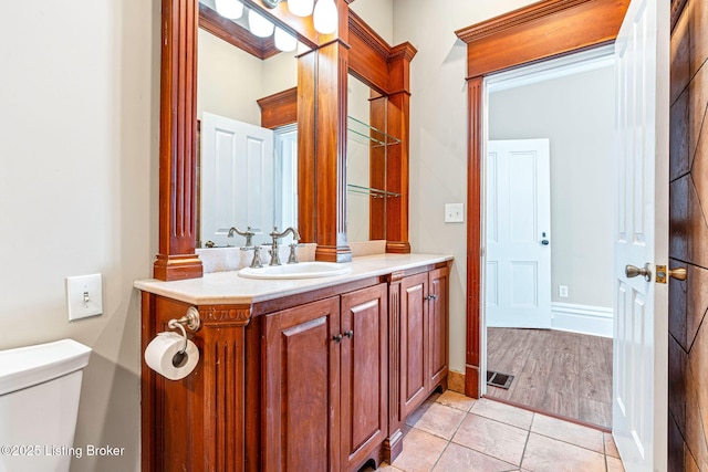 bathroom featuring toilet, vanity, and tile patterned floors