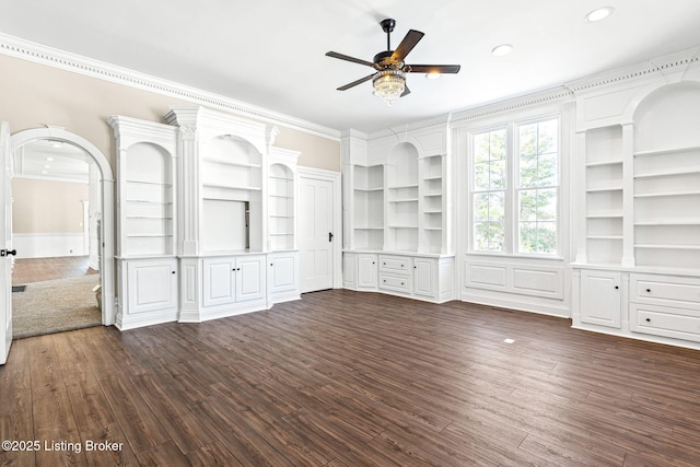 unfurnished living room featuring ceiling fan, built in features, dark hardwood / wood-style flooring, and ornamental molding