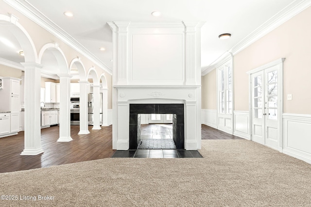 unfurnished living room featuring decorative columns, dark hardwood / wood-style floors, a multi sided fireplace, crown molding, and sink