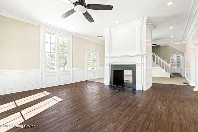 unfurnished living room featuring ceiling fan, dark wood-type flooring, a multi sided fireplace, and ornamental molding