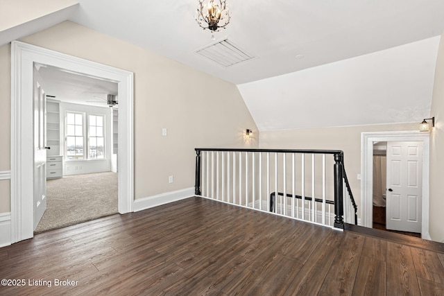 additional living space with dark hardwood / wood-style flooring, lofted ceiling, and ceiling fan with notable chandelier