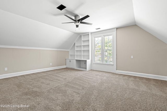 bonus room with ceiling fan, built in shelves, carpet floors, and vaulted ceiling