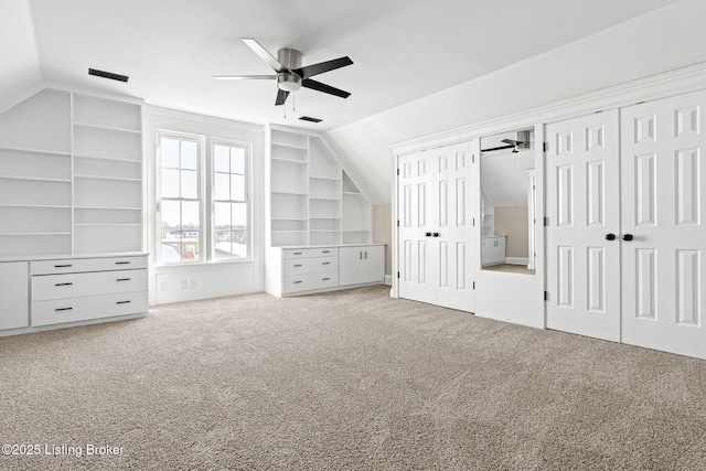 bonus room featuring ceiling fan, vaulted ceiling, built in features, and light carpet