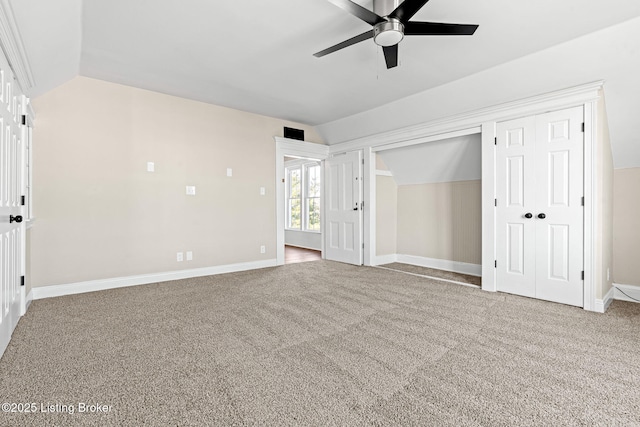 unfurnished bedroom with ceiling fan, a closet, lofted ceiling, and carpet flooring