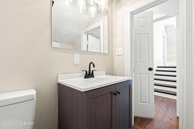 bathroom with toilet, wood-type flooring, and vanity