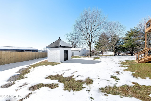 yard covered in snow with a storage shed