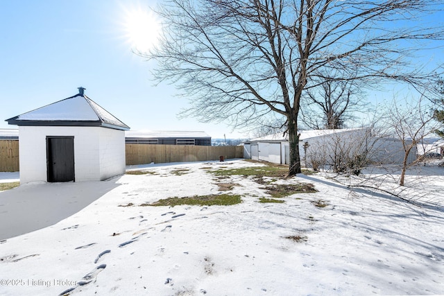 yard layered in snow featuring a storage unit