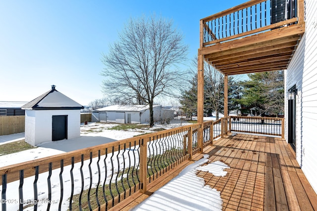 snow covered deck with a shed