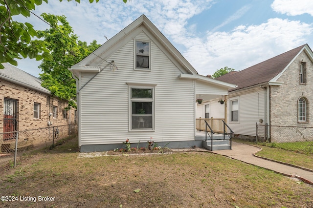 back of property featuring a lawn