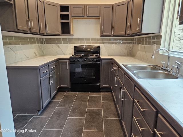 kitchen with dark brown cabinets, gas stove, tasteful backsplash, and sink