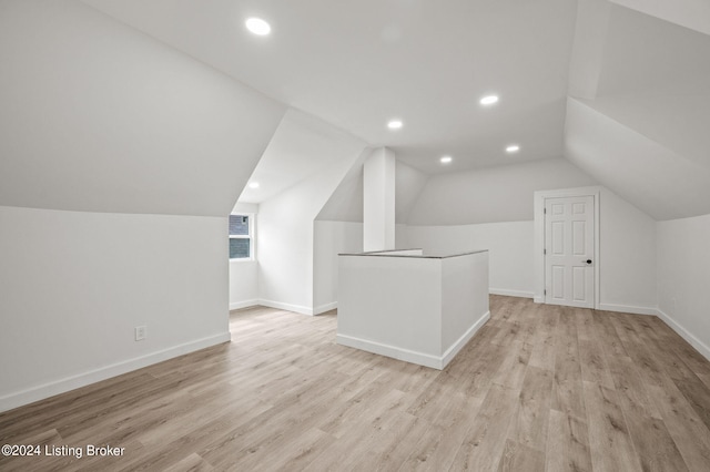 bonus room with light hardwood / wood-style floors and vaulted ceiling