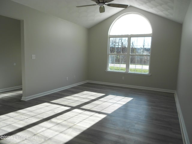 empty room with ceiling fan, dark hardwood / wood-style flooring, and lofted ceiling