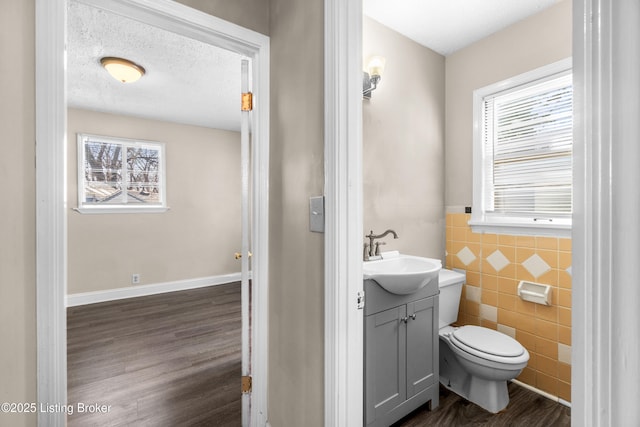 bathroom with hardwood / wood-style flooring, toilet, a textured ceiling, and a wealth of natural light