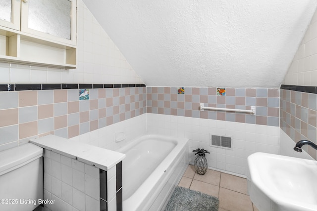 bathroom with tile patterned flooring, sink, tile walls, and a washtub