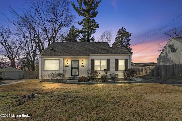 view of front of house featuring an outbuilding, a garage, and a yard