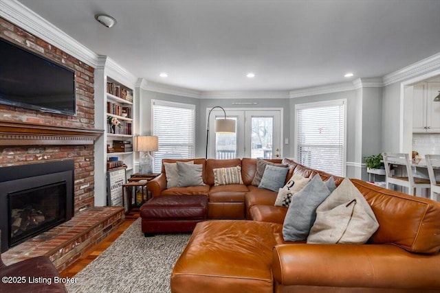 living room with a brick fireplace, ornamental molding, and hardwood / wood-style flooring