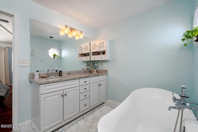 bathroom with a tub to relax in and vanity