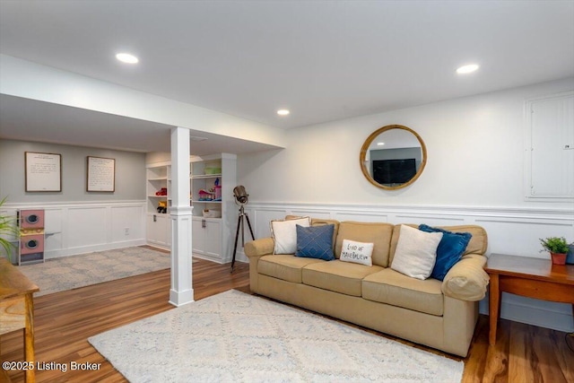 living room featuring built in shelves and hardwood / wood-style floors